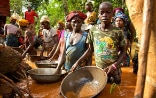 Donne, uomini e bambini di un villaggio della Sierra Leone che, immersi nell’acqua fino alle anche in una miniera d’oro, cercando di eliminare le impurità dell’oro estratto.