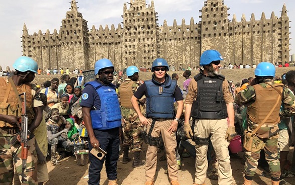  Photograph of UN police officers standing in front of the Great Mosque of Djenné in Mali while on patrol in the city. 