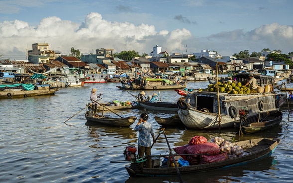 Le donne guidano le barche che trasportano cibo sul fiume Mekong. 
