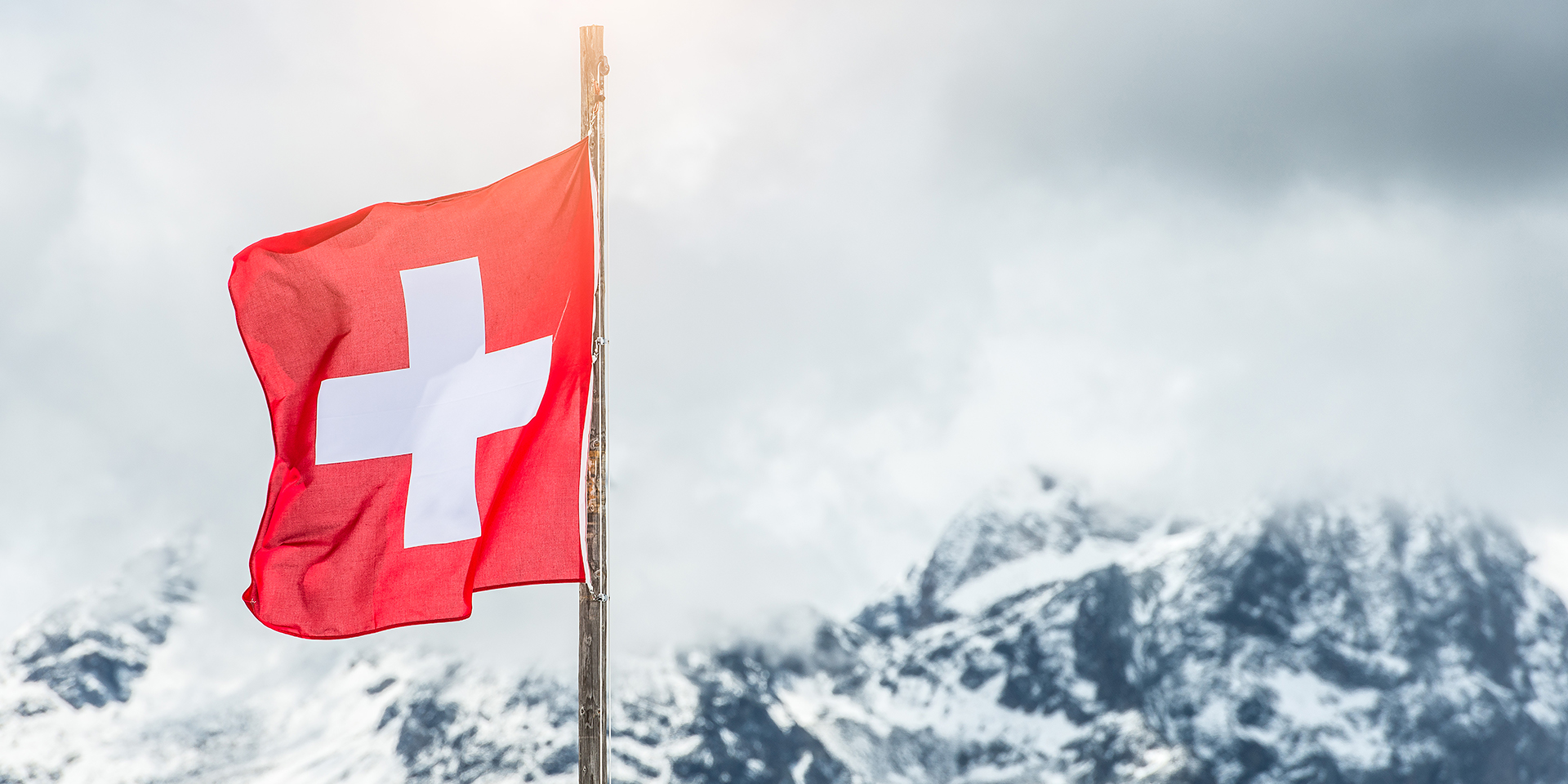 La bandiera svizzera davanti alle montagne.