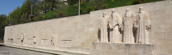 日内瓦宗教改革纪念碑的照片。纪念碑是一面长达100米的浅色石墙，上面雕刻着日内瓦宗教改革的主要人物。
