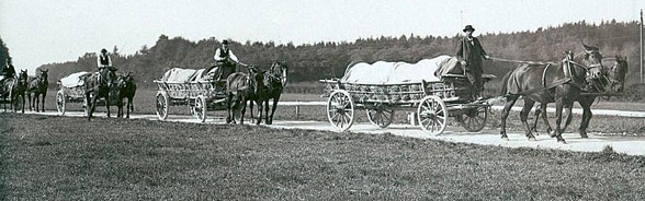 Schwarz-Weiss Aufnahme eines Käsetransports mit Pferd und Wagen.