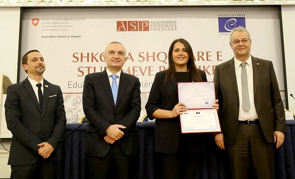 Albania's President Ilir Meta and Swiss Ambassador Adrian Maître handing out diploma certificates to new graduates from the School of Political Studies. 