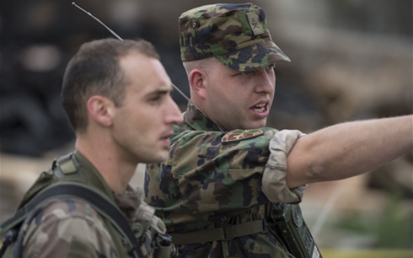 Un militaire français et un militaire suisse en action