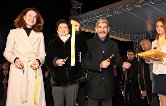 the Georgian Justice Minister holds the cut ribbon symbolizing the opening of the center