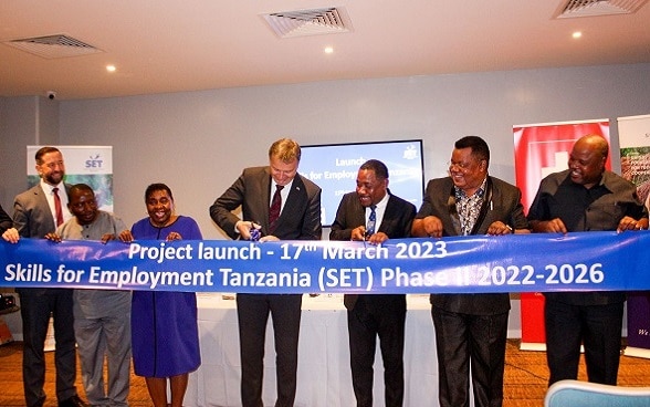 Ambassador Chassot and Deputy Minister Kipanga (4th and 5th from left) cut the ribbon at the launch event.