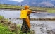 A trained community-owned resource person (CORP) applies biolarvicide to a mosquito breeding site in Tanga.