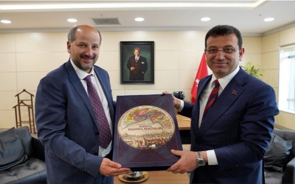 The mayors of Lausanne and Istanbul jointly hold a collection of the maps of Istanbul.