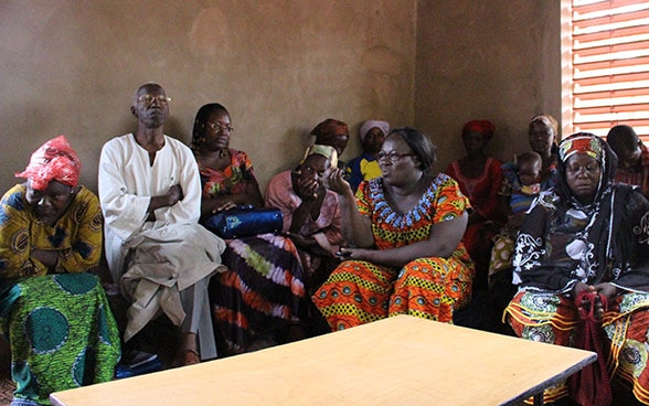 Eine Gruppe von Frauen in Burkina Faso diskutiert in einem Raum.