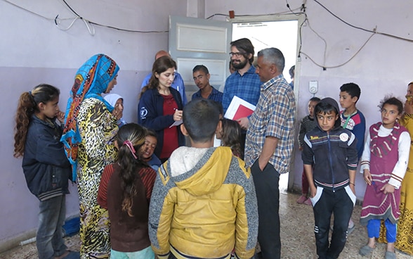 Stefan Bumbacher, accompagné par une collaboratrice du PAM, discute avec un groupe de déplacés. 