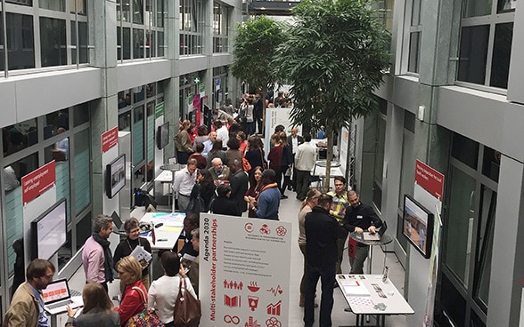 Visiteurs de la Foire de la recherche se promenant et échangeant dans les divers stands.