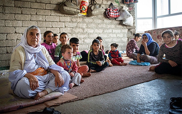 Yazidi women sit in a room in unfinished building being shared with a total of over 100 refugees near Duhok, Iraqi Kurdistan, Northern Iraq.