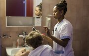 Samrawit, una giovane eritrea, è stata fotografata sul posto di lavoro, in una residenza per anziani in Vallese, mentre spazzola i capelli a una signora.