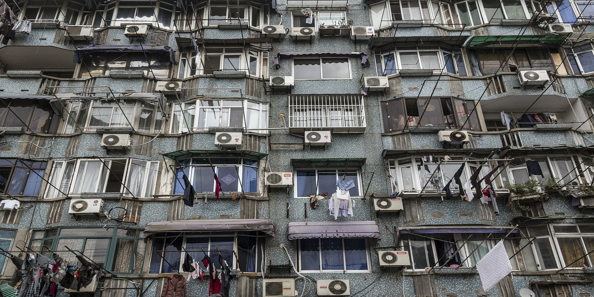 La facciata di un condominio con molti condizionatori ormai vecchi.