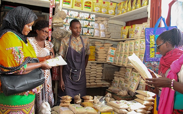 Die Inhaberin mit Angestelltem und Kundschaft in ihrem Laden in Bujumbra.