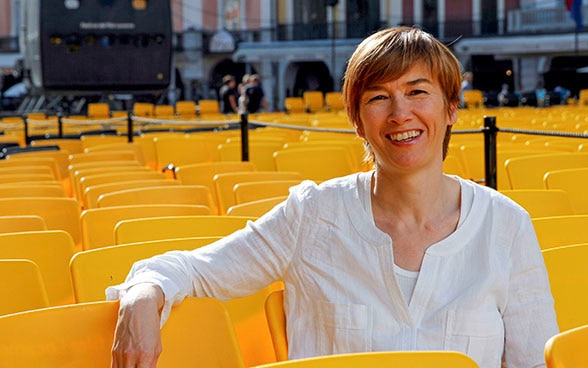 La responsable de Open Doors, Sophie Bourdon, sentada sobre una silla amarilla del Locarno Film Festival, en la Piazza Grande de Locarno.