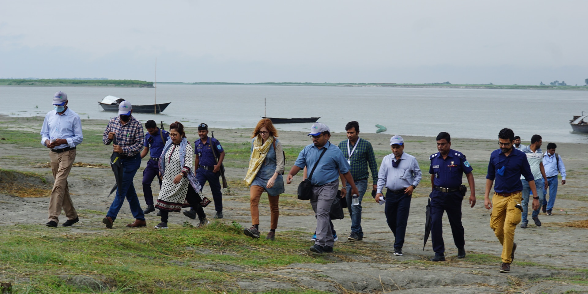 Un groupe de femmes et d’hommes arpentent une île fluviale.