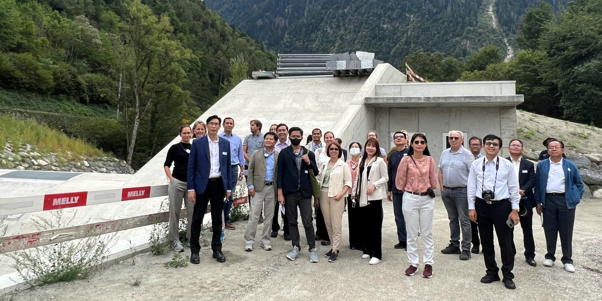 The two Asian delegations posing in front of a dam in Martigny.