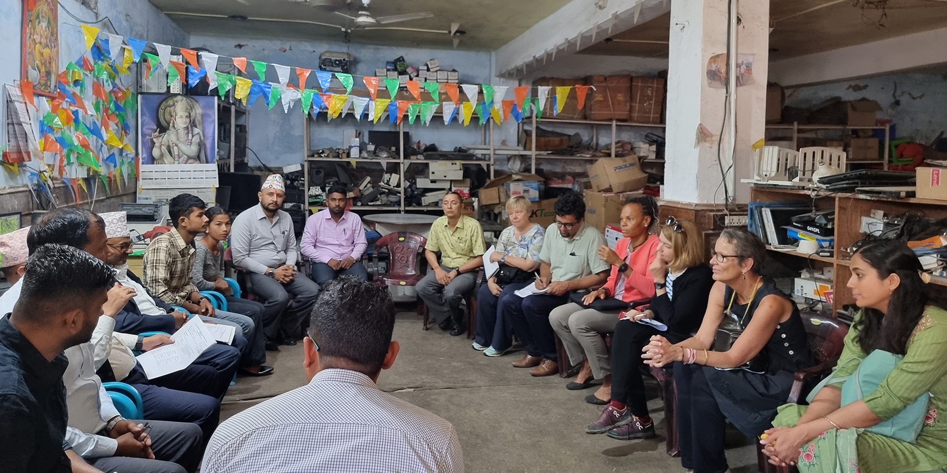 La directrice de la DDC Patricia Danzi lors de la visite d'un centre de formation informatique au Népal. Les participants à la discussion sont assis en cercle. Parmi eux, deux élèves.