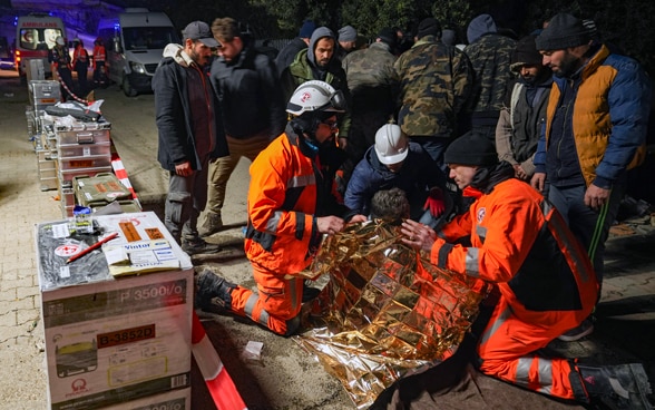 I membri della catena di salvataggio si inginocchiano accanto a una ragazza appena salvata.