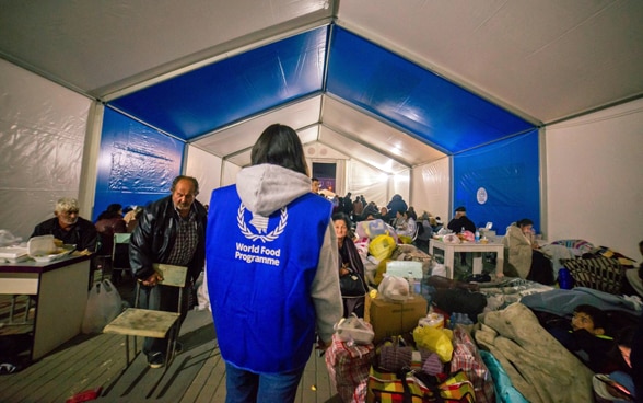 Eine Mitarbeiterin des Welternährungsprogramms steht in einem Zelt. 
