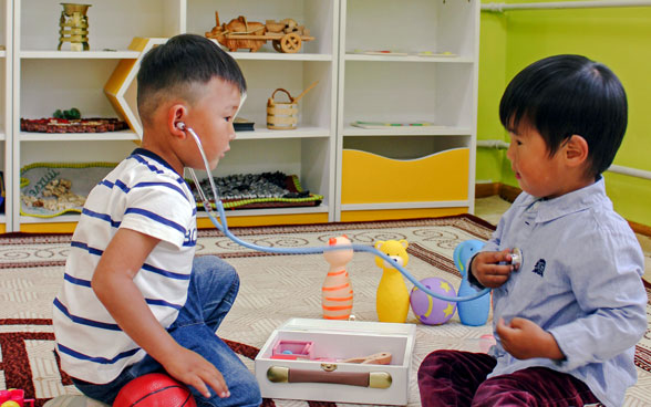 Niños jugando en un jardín de infancia calentado.