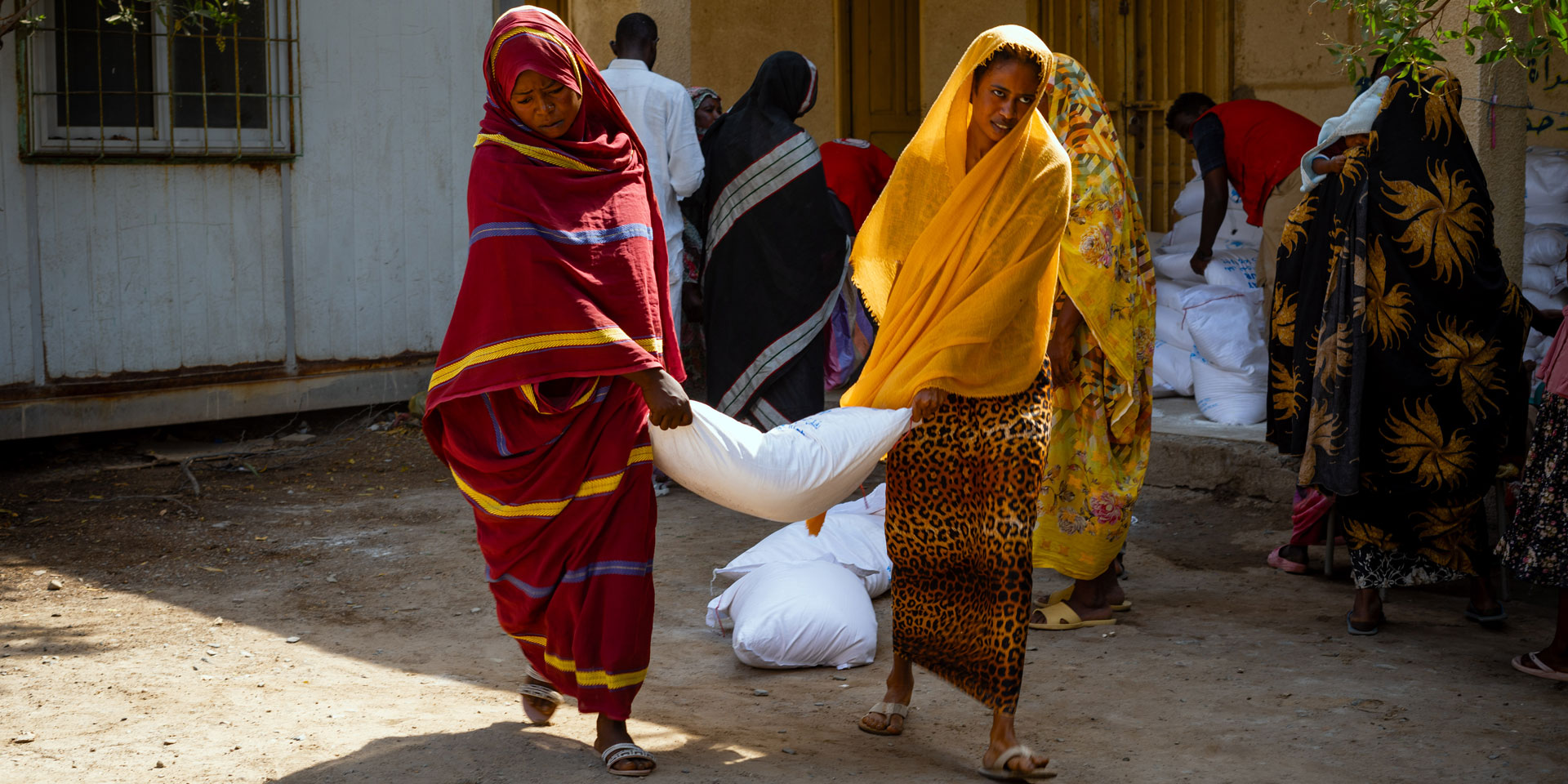 Deux femmes portent un sac de graines.