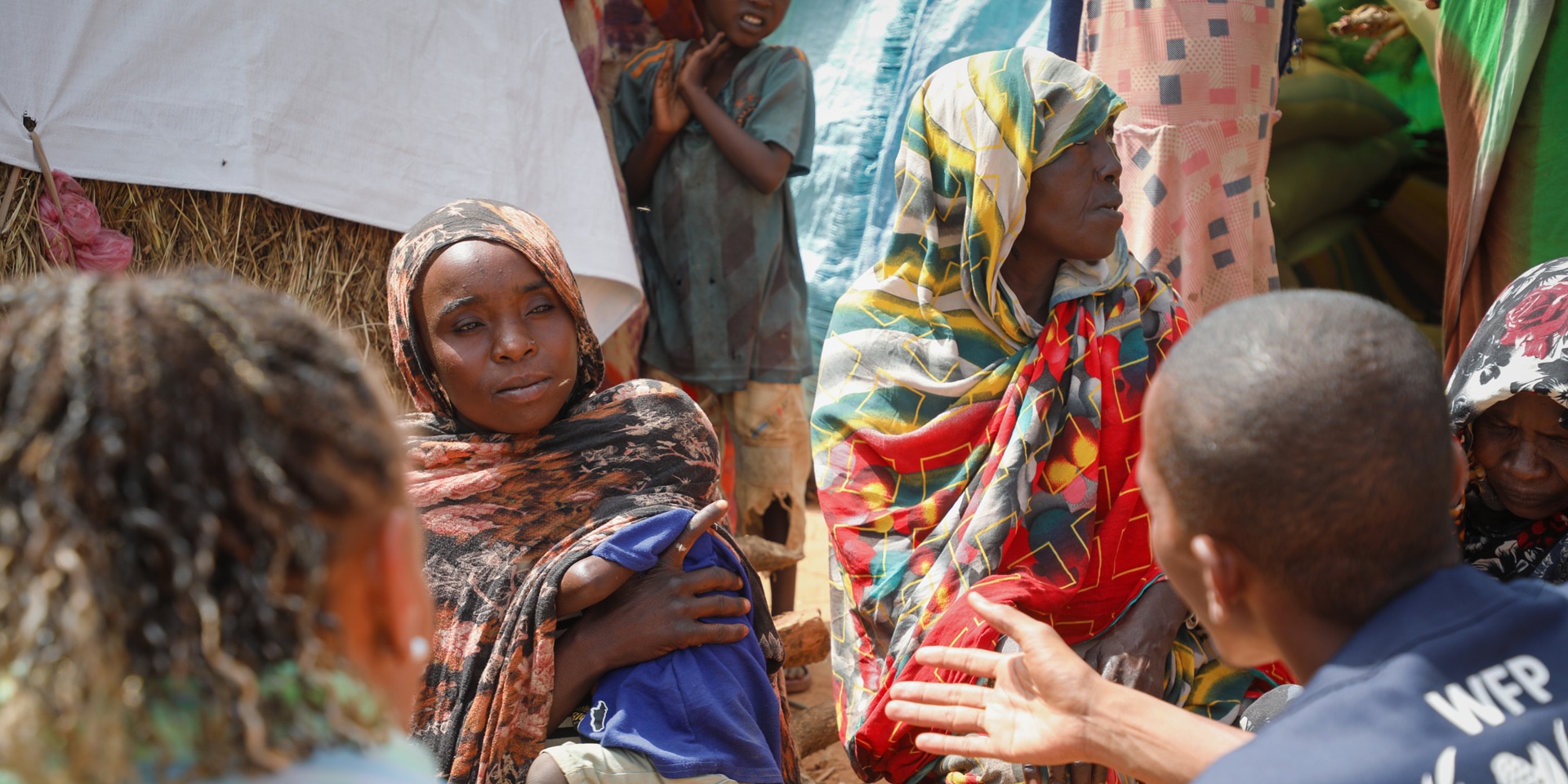 El personal humanitario, junto a Patricia Danzi, conversa con un grupo de mujeres vestidas con las telas típicas de Chad.