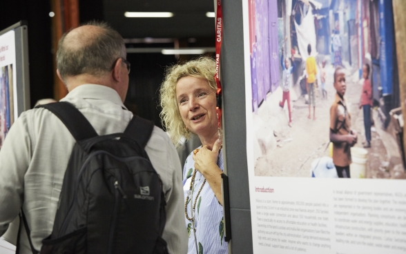 A participant talking to a stand supervisor at the exhibition of the partner organisations.