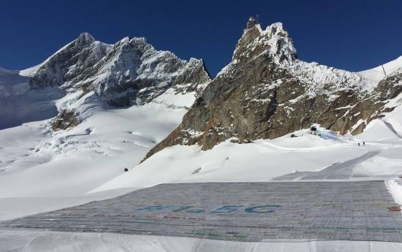 Auf einem Gletscher sind viele Einzelpostkarten zu einer grossen Postkarte zusammengefügt.