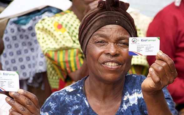 Una campesina africana muestra su tarjeta de miembro de Agri-Fin Mobile.