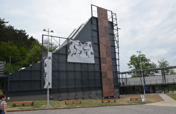 Le bâtiment gris du plus grand centre d’escalade de Hongrie construit dans le cadre du projet Zemplén se détache sur le fond d’un espace vert.