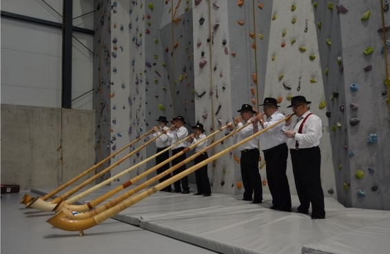 Sei musicisti svizzeri in costume tradizionale danno un concerto di corno delle Alpi nella nuova palestra di arrampicata della città di Sátoraljaújhely.