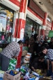 Aid recipients in Iraq queuing outside a supermarket at a point of distribution for food and other goods.