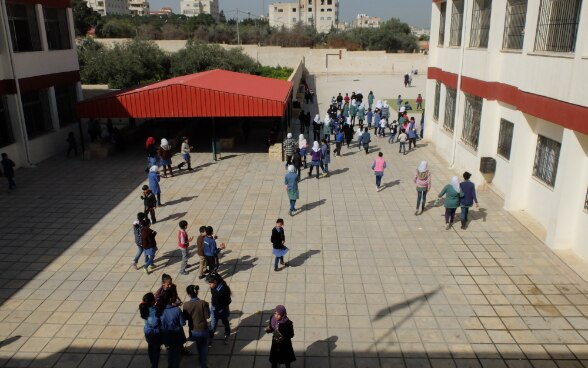 Boys and girls playing in the yard of a rehabilitated school.