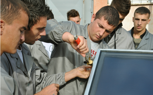 Un jeune assembledes capteurs solaires.