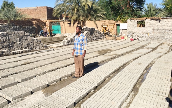 A villager helps make bricks to repair irrigation canals. © SDC