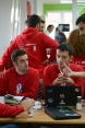 Quattro giovani sviluppatori seduti intorno a un tavolo discutono possibili soluzioni informatiche che permettano all’amministrazione comunale di garantire maggiore trasparenza.