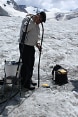 Deux hommes s’activent avec leur matériel sur un glacier.