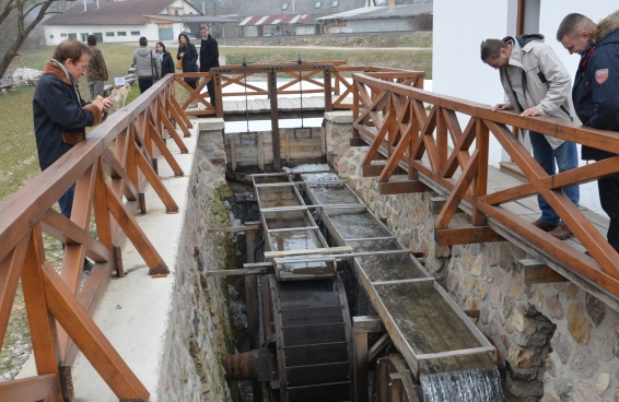 A group of tourists visit a fully renovated two-hundred-year-old water mill.