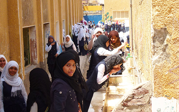Des jeunes filles d’une école secondaire à Assouan boivent l’eau des robinets installés dans la cour de récréation.