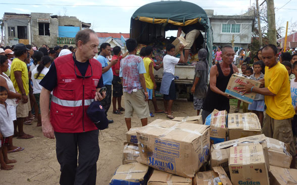 Un membre du Corps suisse d'aide humanitaire supervise la distribution des biens de première nécessité. 