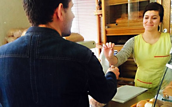 Fatjona Halimi serving a client in the bakery