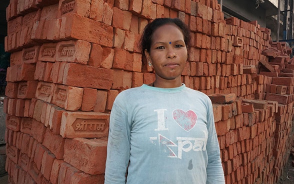 Rohini Devi Chaudhary pose devant une pile de briques.