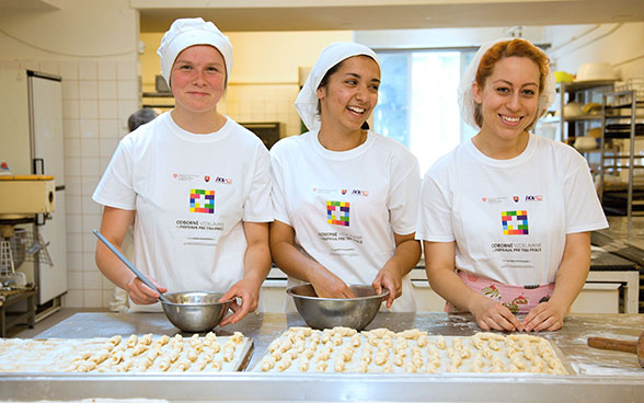 Tres aprendices de panadería-repostería fabrican pequeños croissants 