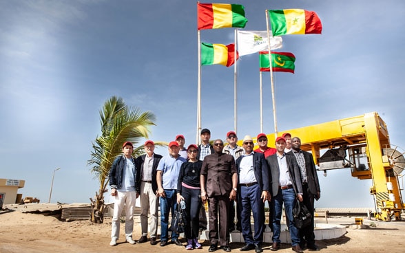 Hochrangige Regierungsvertreter aus Zentralasien und Westafrika stehen gemeinsam vor einer grossen Wasserleitung. 