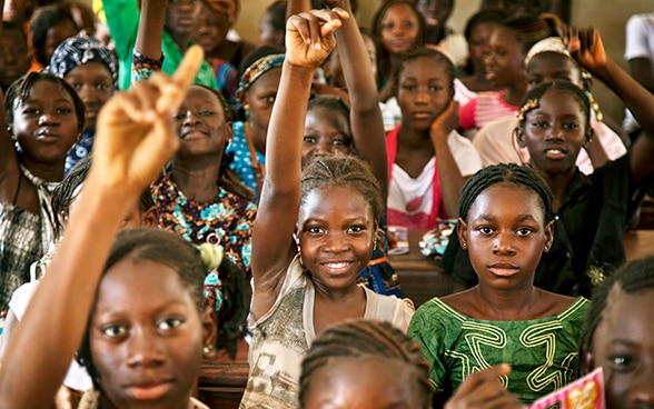 Des jeunes filles africaines lèvent la main. 