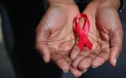 Hands holding a band representing the AIDS symbol.