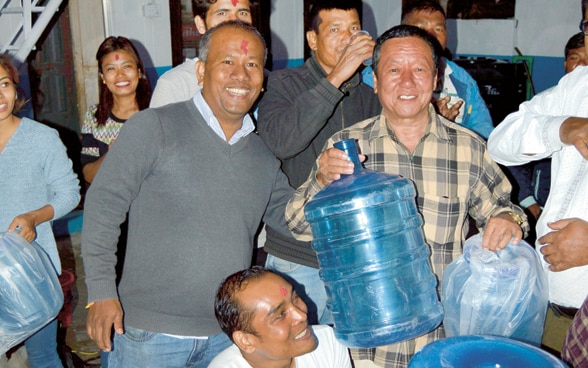 Zehn Personen mit Wasserflaschen in Nepal.