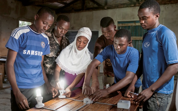 Young men and a young woman are trained to become electricians in a vocational training centre in Tanzania.